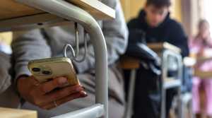Etudiant qui triche avec son téléphone portable pendant un examen