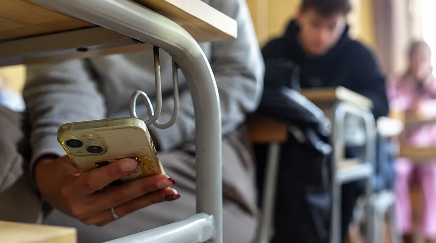 Etudiant qui triche avec son téléphone portable pendant un examen