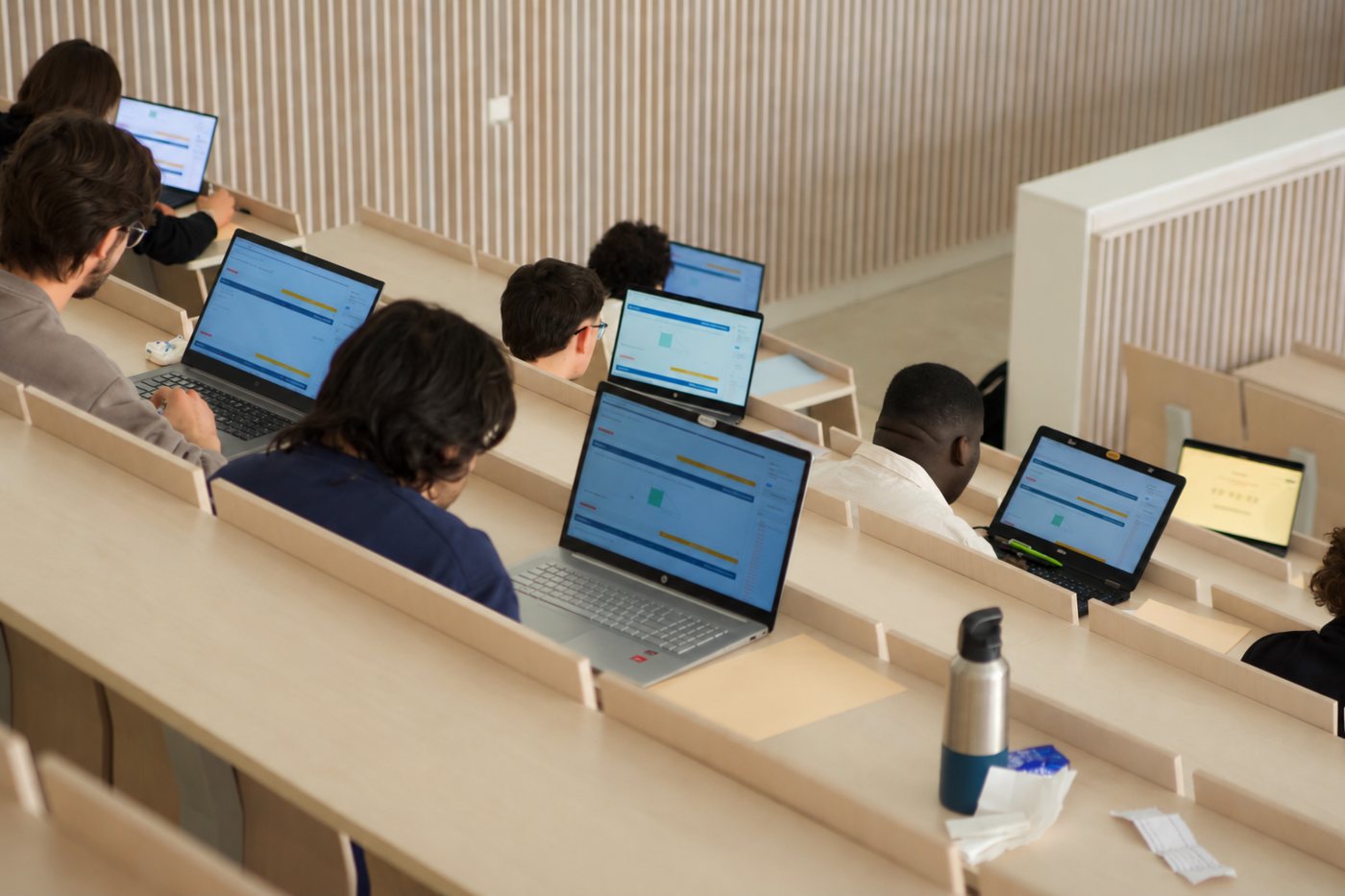 Étudiants composant sur ordinateur dans un amphithéâtre